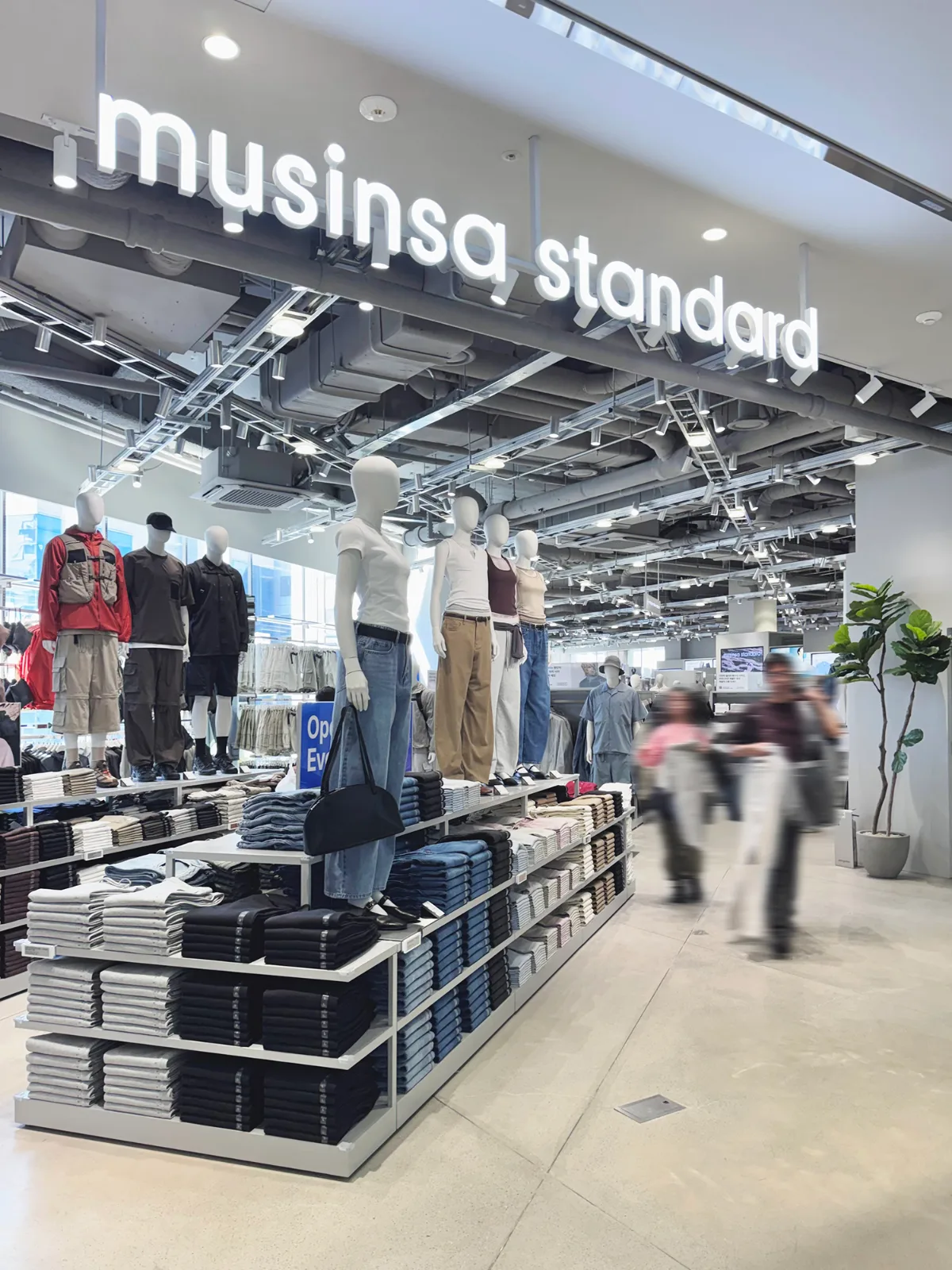 衣類が整然と並ぶ白い売り場