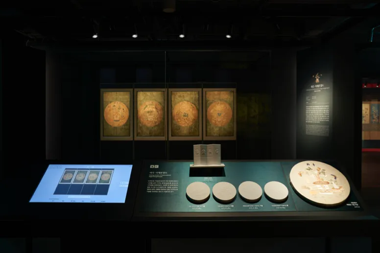 円形文様の作品と解説端末が並ぶ展示